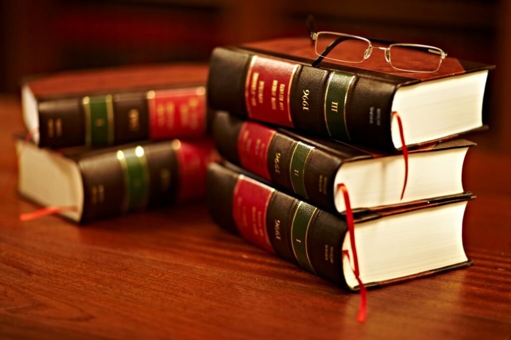 Shot of a stack of legal books and a pair of glasses on a table in a study